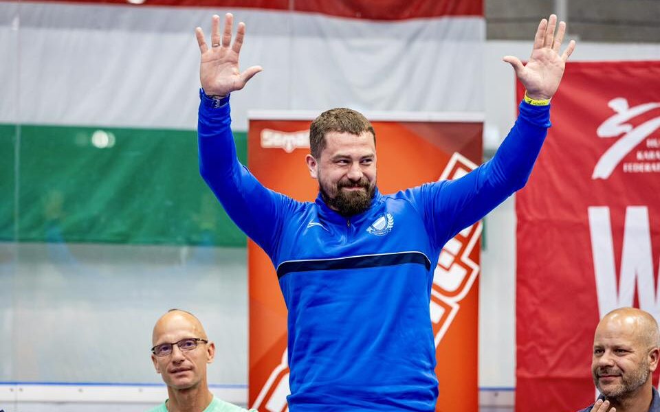 Hárspataki Gábor az UTE Jégcsarnokban két kézzel integetve búcsúzik az élsporttól, mellette bal oldalon edzője, Fischer Mihály áll.